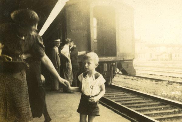 old picture of a young boy and adult at a train station
